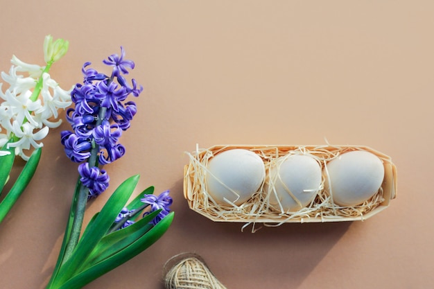 Fond de Pâques avec des fleurs de jacinthe, des œufs sur fond marron.