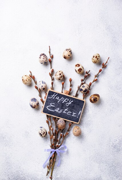 Fond de Pâques avec des oeufs de caille et du saule