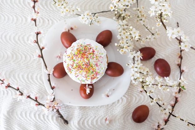 Fond de Pâques avec des oeufs colorés, des oeufs de Pâques colorés et des branches fleuries. Composition de Pâques. Gâteau de Paques.