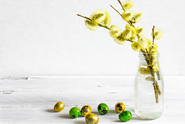 Fond de Pâques avec des oeufs de Pâques et des branches de saule en fleurs