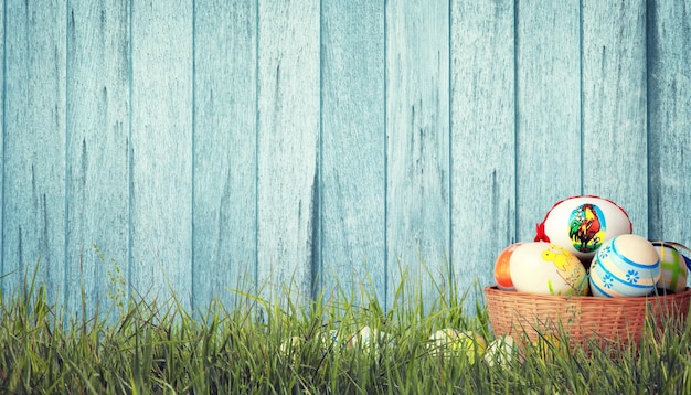 Fond de Pâques avec des oeufs de Pâques colorés sur fond de bois