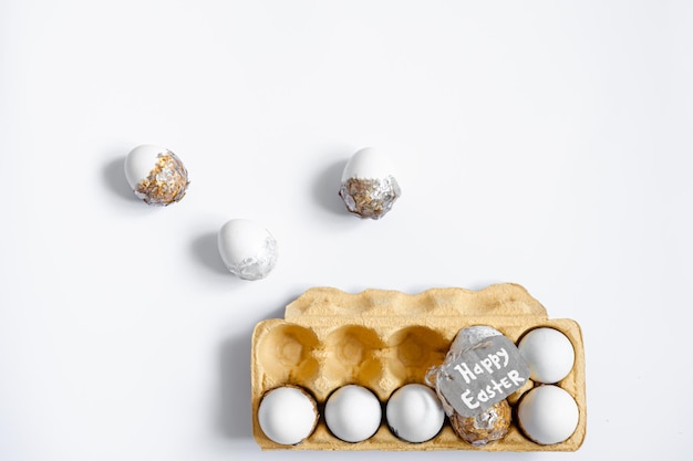 Fond de Pâques avec plateau d'oeufs décoratifs isolé sur plat blanc