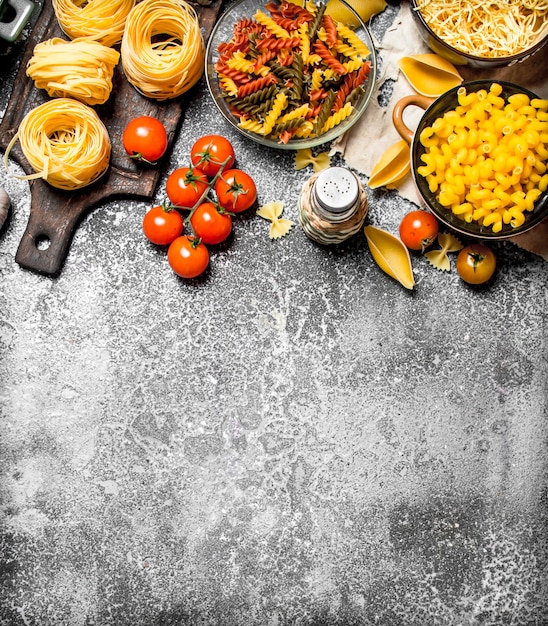 Fond de pâtes Pâtes aux sauces, légumes et huile d'olive sur fond rustique