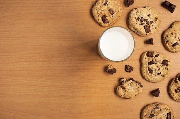 Fond plat de biscuits au chocolat et barre de chocolat et une tasse de lait