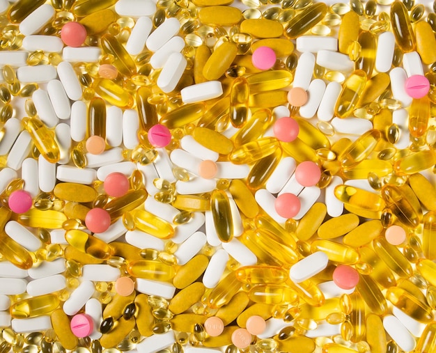 Fond plat de pilules médicales multicolores et de gélules en gros plan