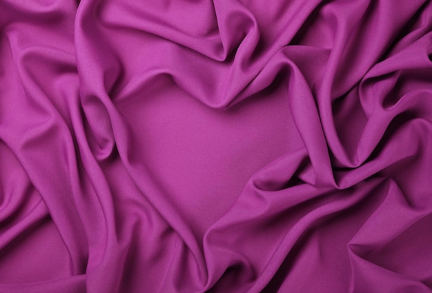 Photo fond de plis de pli textile en forme de coeur rose