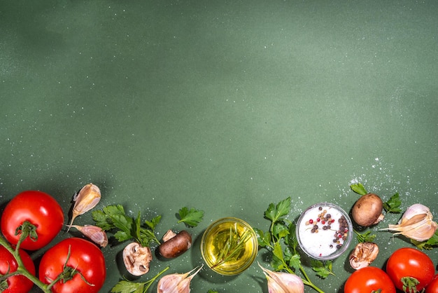 Fond de préparation de cuisine alimentaire Fond de table de cuisine avec épices herbes légumes persil oignon ail tomates sel huile d'olive sur fond vert foncé vue de dessus espace de copie plat