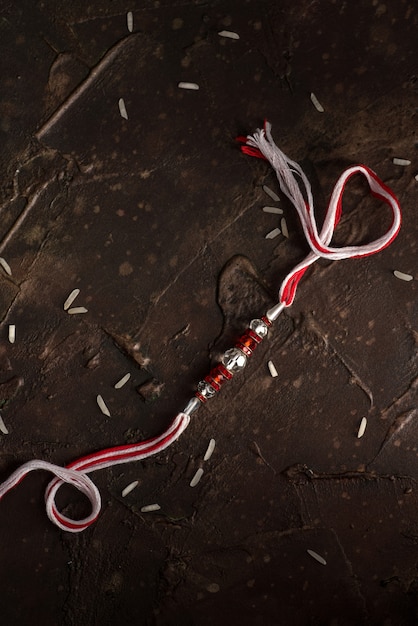 Fond de Raksha Bandhan avec un Rakhi élégant et du riz dispersé