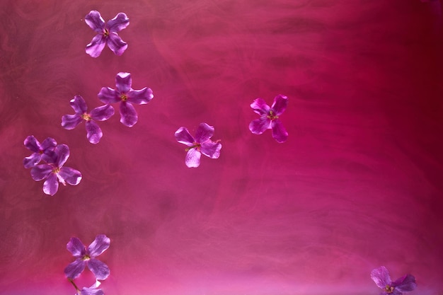 Fond rose abstrait avec des fleurs et des peintures dans l'eau Toile de fond pour les produits cosmétiques de parfum