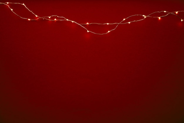 Fond rouge avec des lumières illuminées de guirlande