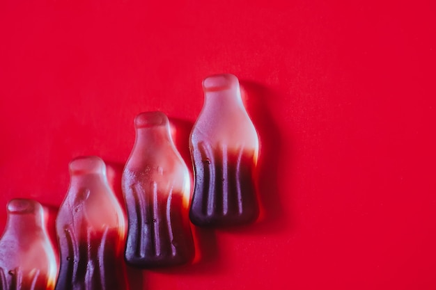 Fond rouge minimaliste avec des bonbons gommeux au cola