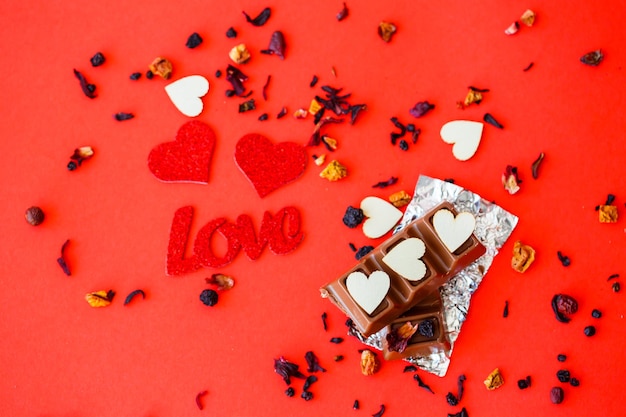 Fond rouge de la Saint-Valentin avec des coeurs en bois et le mot amour. Lieu d'inscriptions, publicité