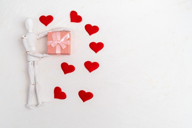 Fond Saint Valentin Une boîte cadeau avec un mannequin en bois sur un fond blanc Mise à plat Copier l'espace