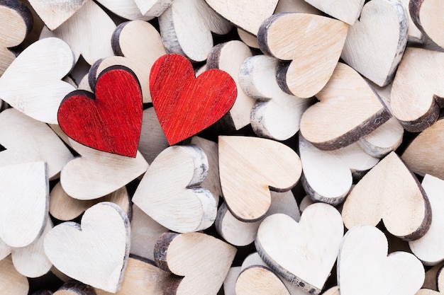 Fond de Saint Valentin avec coeurs rouges fin blanc sur fond en bois.