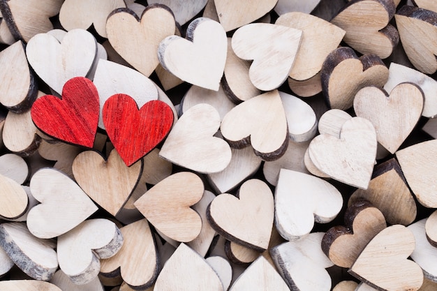 Fond de Saint Valentin avec coeurs rouges fin blanc sur fond en bois.