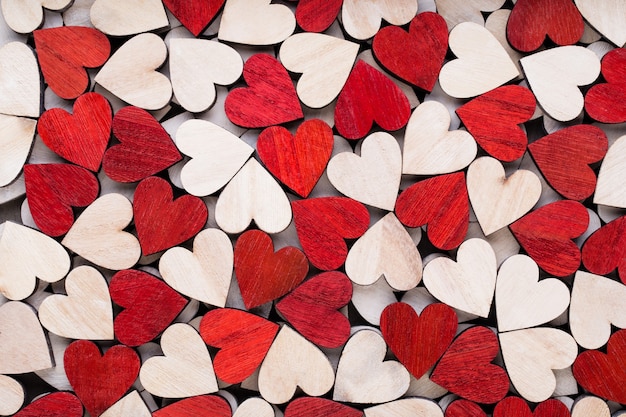 Fond de Saint Valentin avec coeurs rouges fin blanc sur fond en bois.