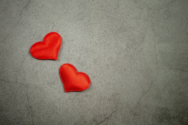 Fond de Saint Valentin avec des coeurs rouges sur la vieille table en béton.