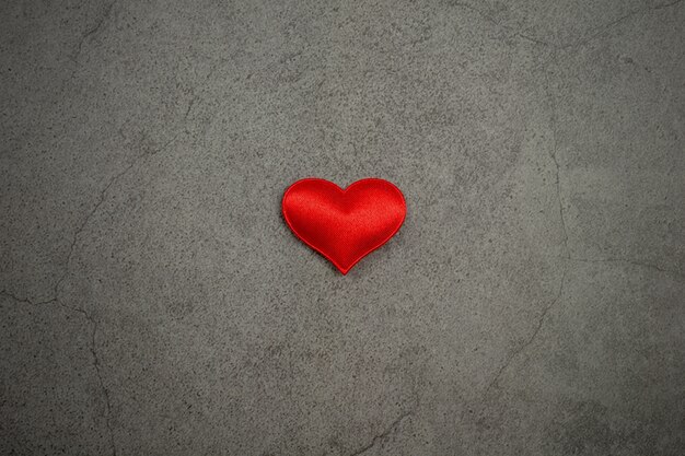 Fond de Saint Valentin avec des coeurs rouges sur la vieille table en béton.