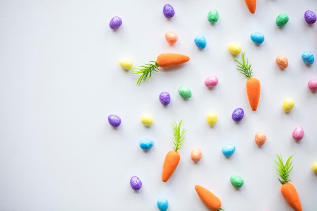 Fond saisonnier de Pâques avec des oeufs et des carottes colorés