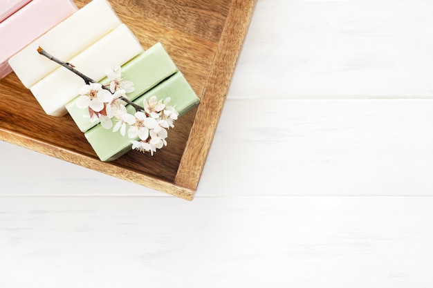 Fond de savon. Savon naturel aromatique aux fleurs de sakura sur fond blanc en bois, vue de dessus