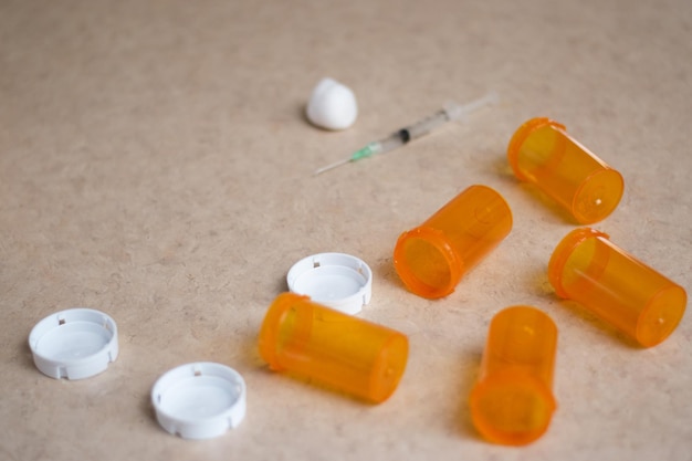 Fond de seringue et de bouteilles vides de médicaments dans un concept de toxicomane de table et espace de copie