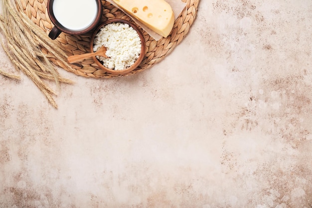 Fond de Shavuot heureux pour la célébration juive religieuse traditionnelle de Shavuot Lait et fromage blé et fruits mûrs Produits laitiers sur fond de mur brun clair ancien Concept de Shavuot Vue de dessus