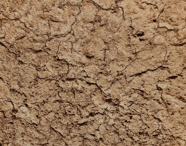 Photo fond de sol sec brun en vue de dessus, le sol se fissure, la stagnation de l'évaporation de l'eau des sables du désert et le réchauffement climatique de grandes fissures dans le sol argileux en raison de l'évaporation de l'eau