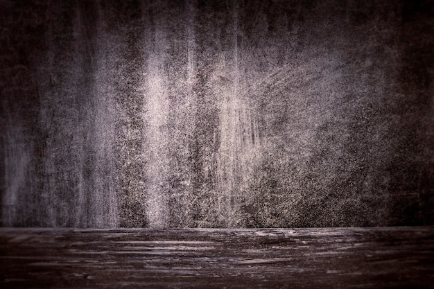 Photo le fond sombre d'un mur texturé et d'un sol en béton.