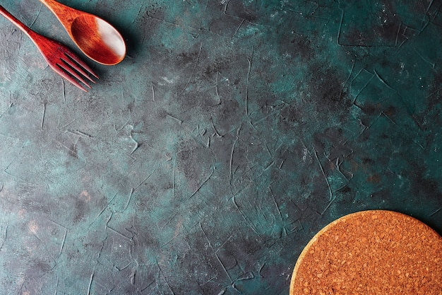 Photo fond sombre avec ustensiles de cuisine cuillère en bois et espace de copie de fourchette pour le menu texte