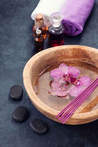 Fond de spa avec huile de bain d'orchidées et pierres zen