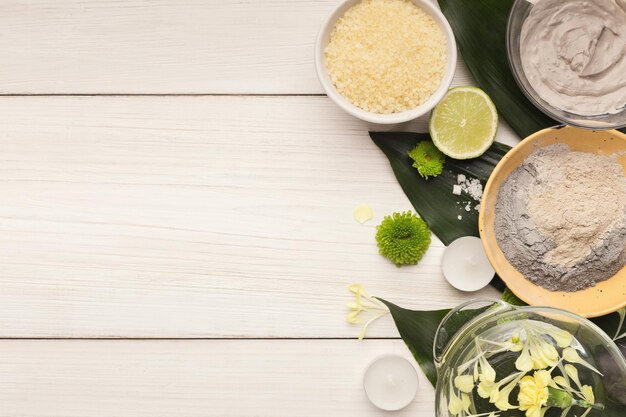 fond de spa. Produits de soins naturels sur de grandes feuilles vertes sur une table blanche. Salon ou soins du corps et de la peau à domicile, espace de copie, vue de dessus