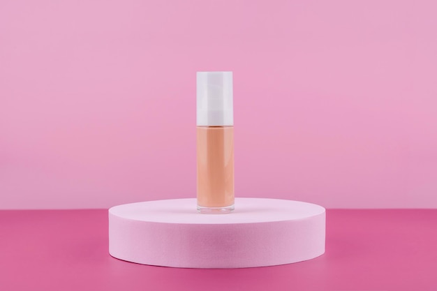 Fond de teint liquide cosmétique maquette de bouteille de crème nude sur socle de podium rond Produit cosmétique de base de correcteur beige maquette sur fond rose Apprêt de beauté pour la peau correcteur bb