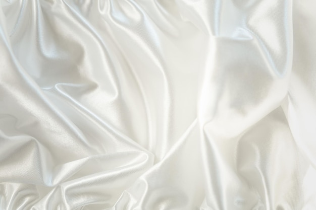 Photo fond textile blanc abstrait satin blanc neigeux ou tissu de soie dans les vagues plis de tissu