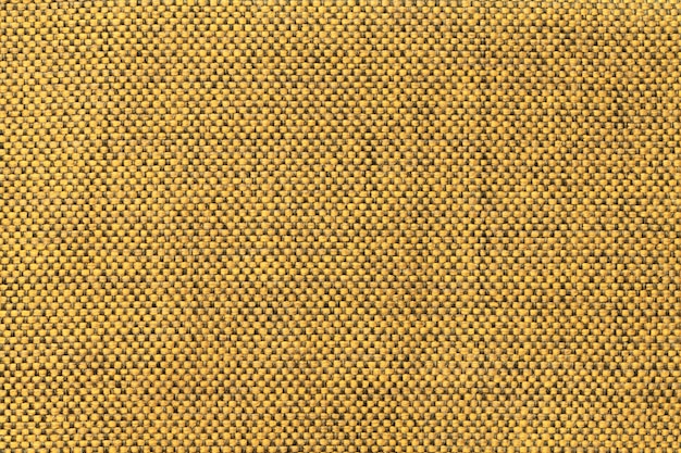 Fond textile jaune foncé avec motif d'échecs, gros plan. Structure de la macro de tissu.