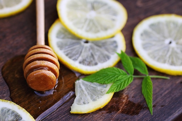 Sur un fond de texture en bois, un citron et du miel sur une cuillère