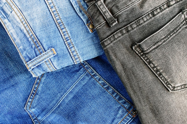 Fond de texture denim Pile de divers jeans en coton avec poches et coutures avec coutures en fil orange vue de dessus