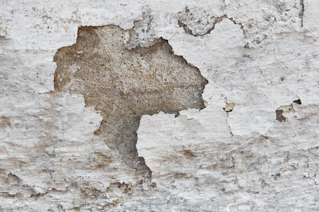 Fond avec texture de mur avec une vieille peinture blanche écaillée.