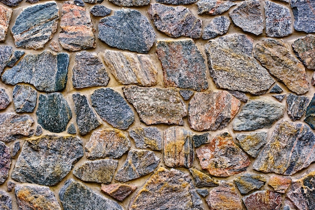 Fond d'une texture de revêtement de mur en pierre, briques de pierre brune