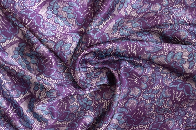 Photo fond de texture de tissu satiné dans les couleurs tendances violet, bleu. écharpe étole magnifiquement torsadée.