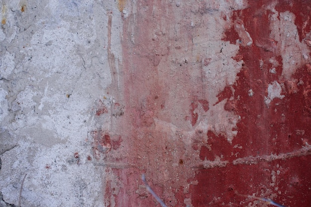 Fond texturé. Vieux mur de béton avec peinture rouge