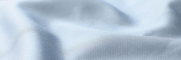 Fond de tissu de soie bleu clair ondulé Gros plan de textile satiné léger