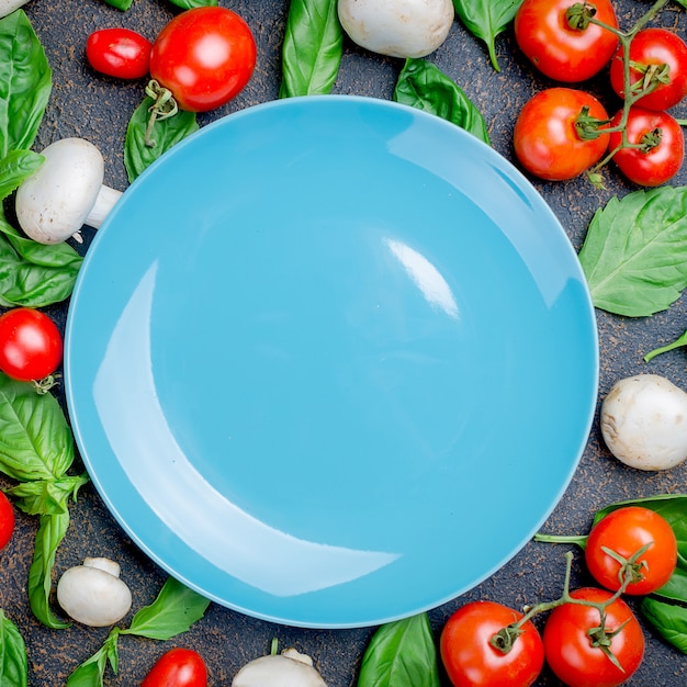 Fond avec des tomates, des champignons et des feuilles de basilic