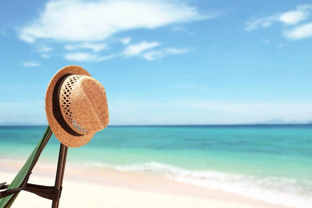 Fond de vacances avec chapeau de paille et plage tropicale lumineuse