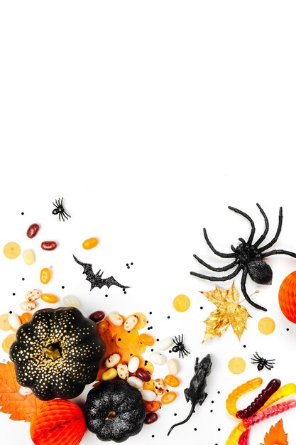 Fond de vacances d'Halloween avec des bonbons colorés, des chauves-souris, des araignées, des citrouilles et des décorations. Mise à plat. Vue d'en-haut