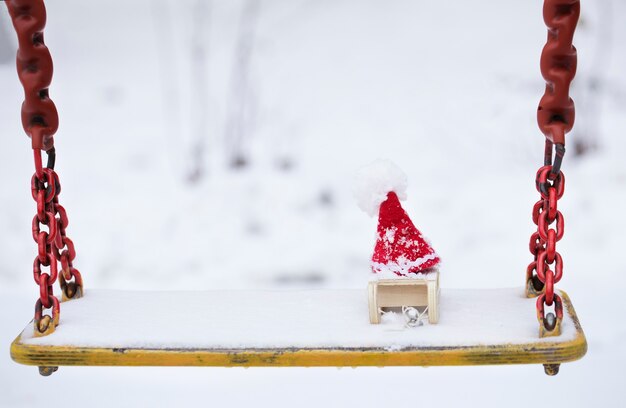 Fond de vacances d'hiver : chapeau de père Noël sur un traîneau en bois. Fermer