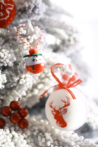 Fond de vacances de Noël. Boule d'argent et de couleur suspendue à un arbre décoré avec bokeh et neige, espace de copie.