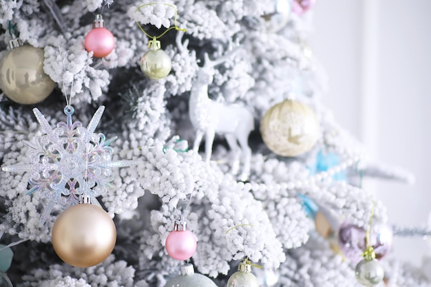 Fond de vacances de Noël. Boule d'argent et de couleur suspendue à un arbre décoré avec bokeh et neige, espace de copie.
