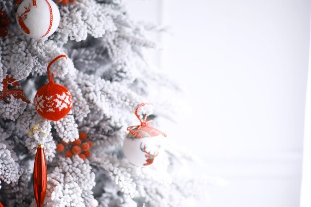 Fond de vacances de Noël. Boule d'argent et de couleur suspendue à un arbre décoré avec bokeh et neige, espace de copie.