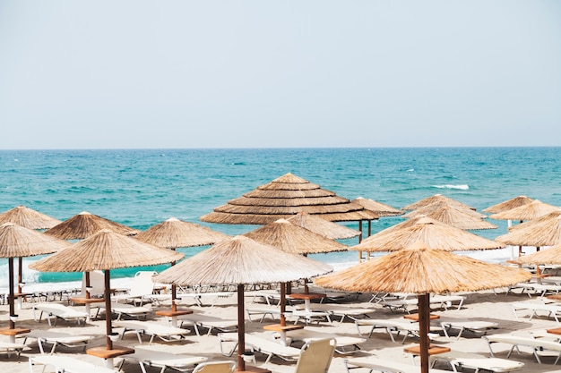 Fond de vacances. Plage avec parasols et vue sur la mer.