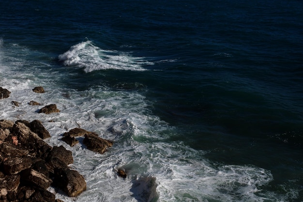 Fond de vague océanique brisant le rivage rocheux de l'eau de mer